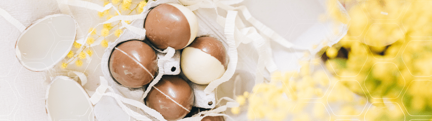 Ovos de Páscoa em embalagem rústica e flores ao lado