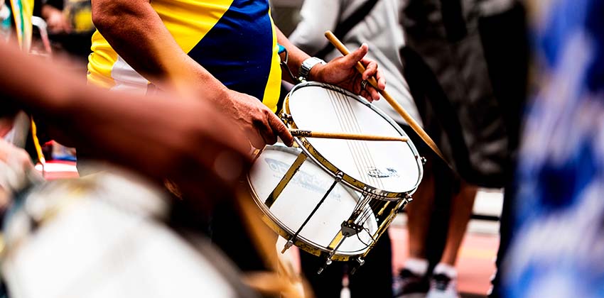 Imagem de pessoas tocando em uma bateria